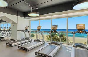 A gym with treadmills, large windows, and a view of the beach. - Splash Resort Luxury * Pools / Lazy River / Water Parks * Sept still Available (Panama City Beach)