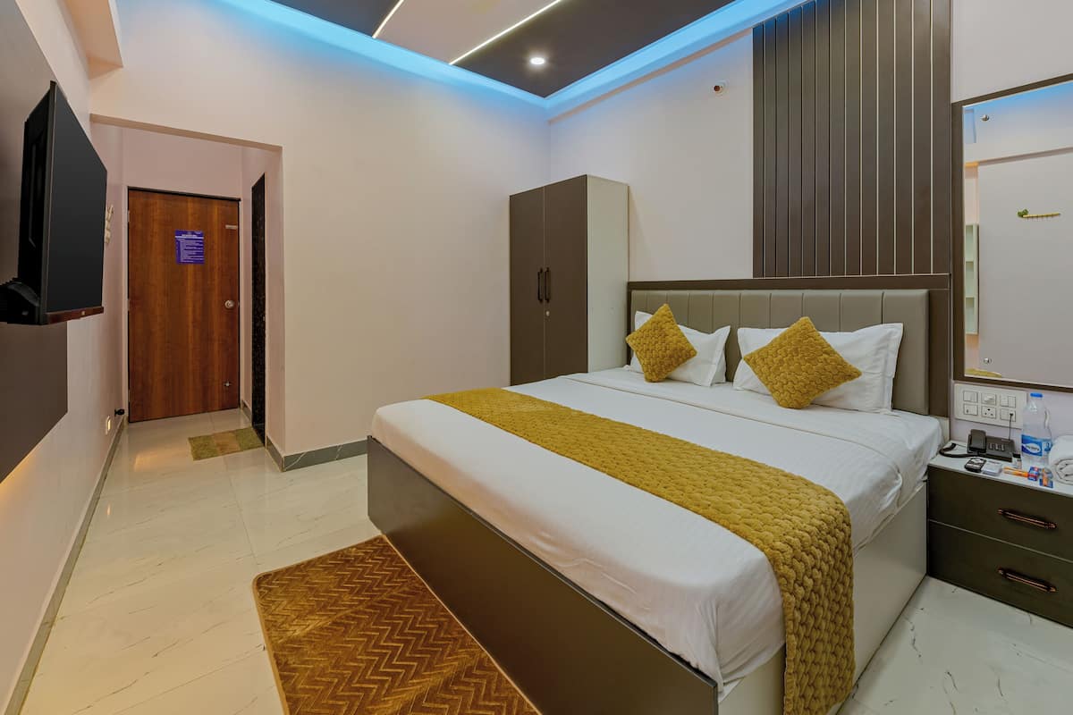 A modern bedroom with a bed, bedside tables, a wardrobe, a ceiling fan, and a flat-screen TV.
