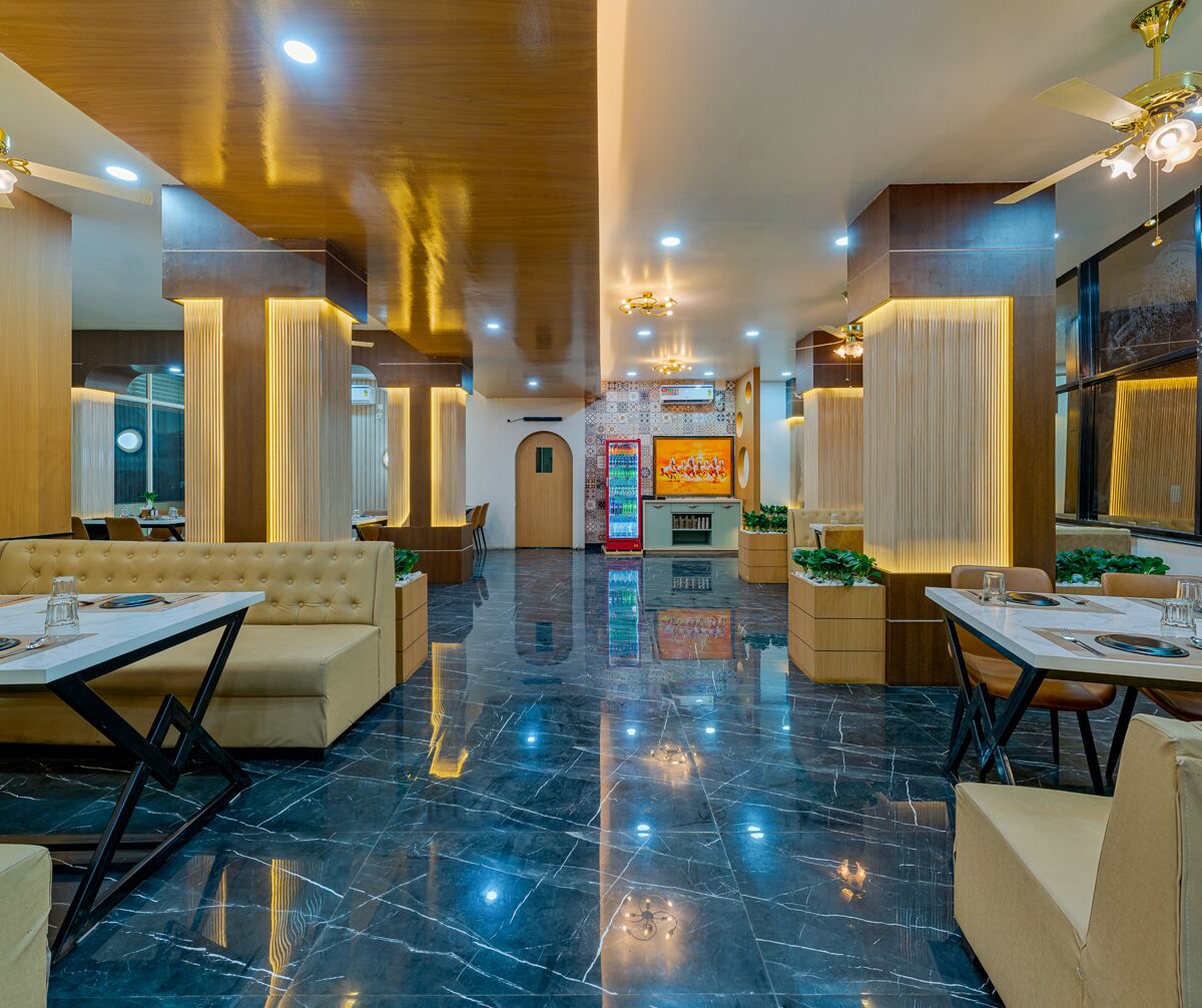 Um hall de hotel espaçoso com área de estar central, frigorífico e máquina de vendas.