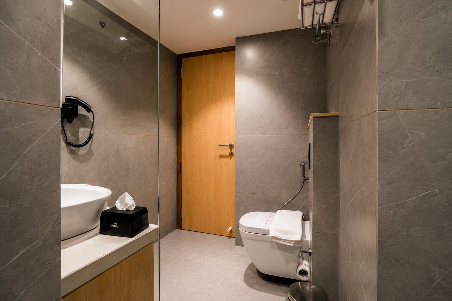 A modern bathroom with a toilet, bidet, and sink.