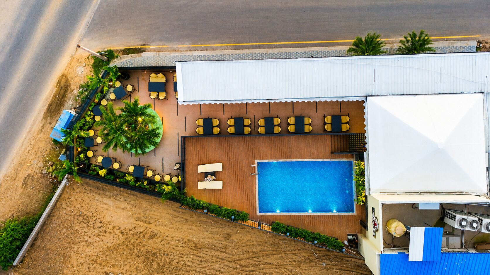A rooftop pool area with a wooden deck, multiple seating areas, and a large swimming pool.