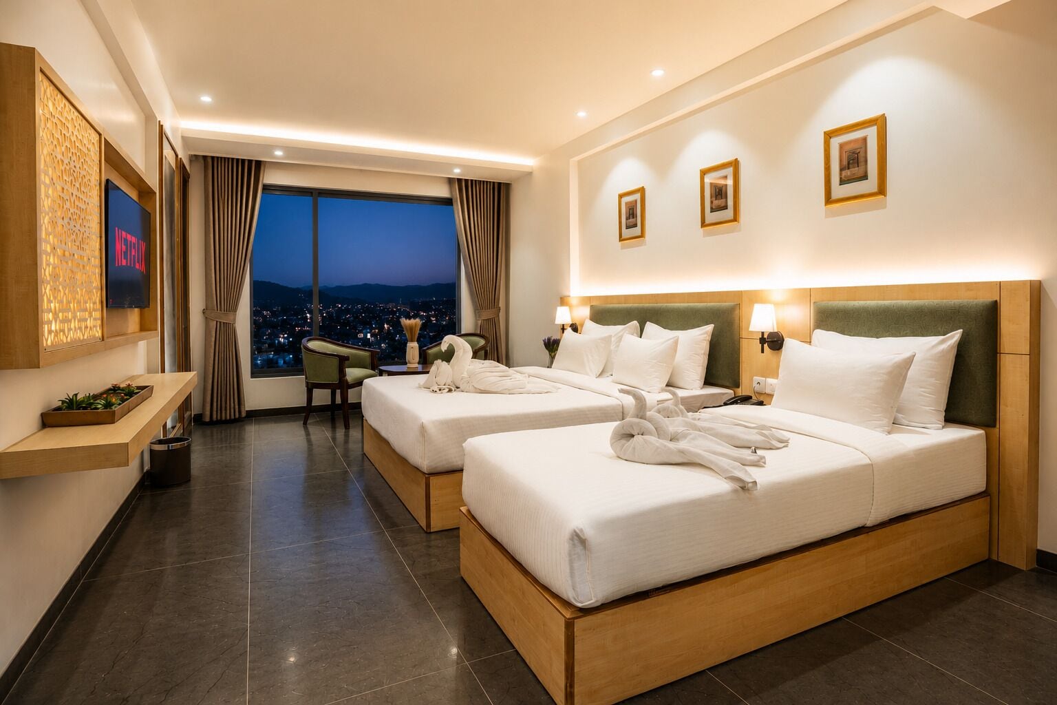 A hotel room with two beds, a city view, a TV, and a desk with a chair.