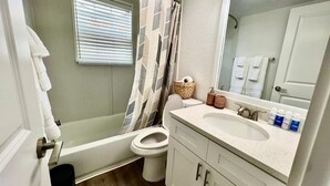 A bathroom with a bathtub, toilet, sink, and a large mirror. - Entire home ,Clean, quiet, and cozy—everything you need for the perfect stay (Virginia Beach)