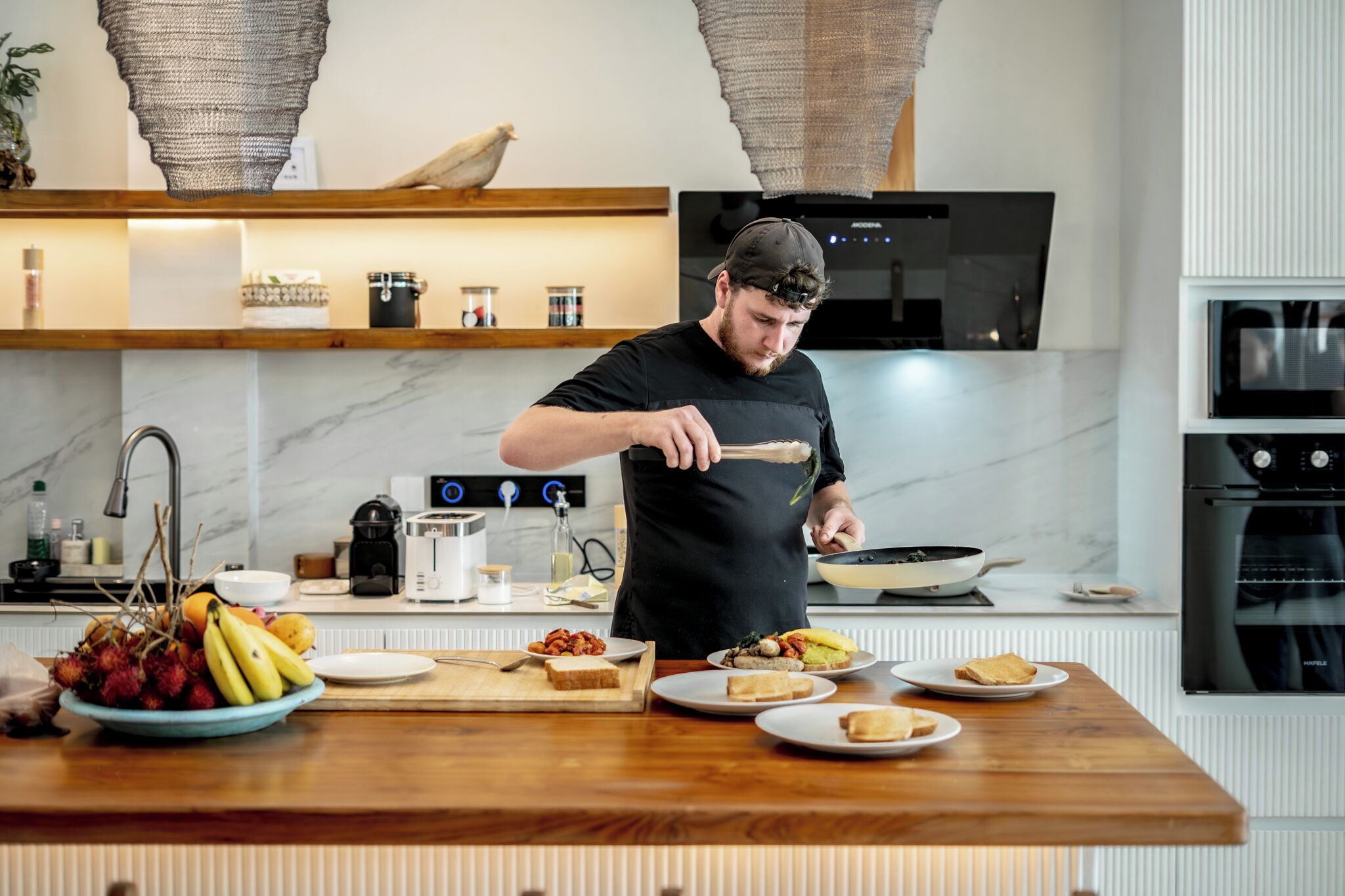 A modern kitchen with a wooden countertop, a stove, and a microwave.
