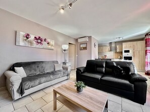 Ein Wohnzimmer mit zwei Sofas, einem Couchtisch und einer Topfpflanze.