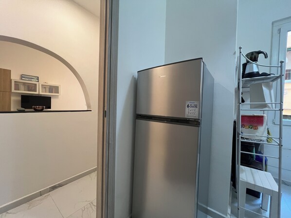 A kitchen with a stainless steel refrigerator, a microwave, and a small countertop with a bowl. - Mameli 6 (Santa Margherita Ligure)