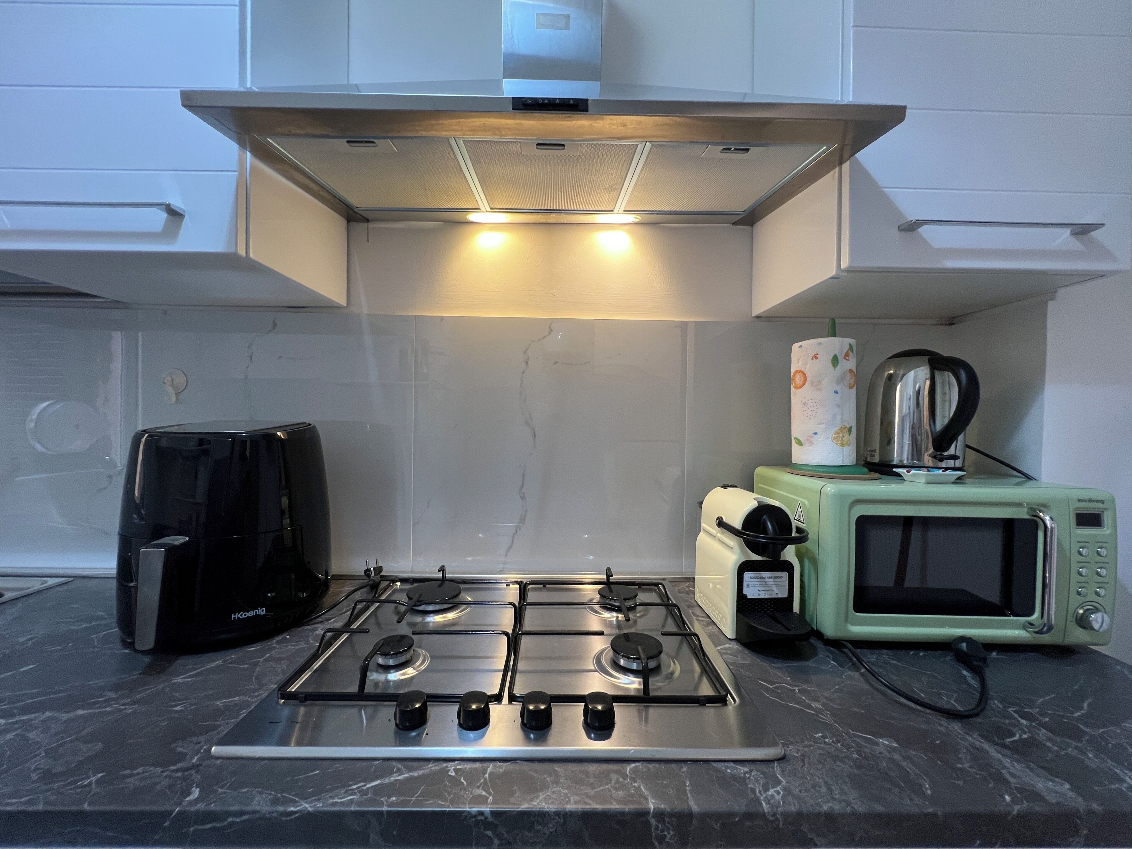 A kitchen with a gas stove, a microwave, and a coffee maker.