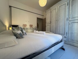 Ein Schlafzimmer mit einem Bett, einem Schminktisch, einem Spiegel und einem Kleiderschrank.