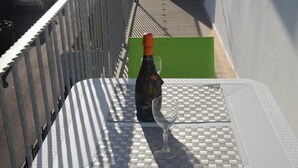 A bottle of wine and a glass on a checkered table mat. - B&b Eden Ogliastra  (Tortolì)