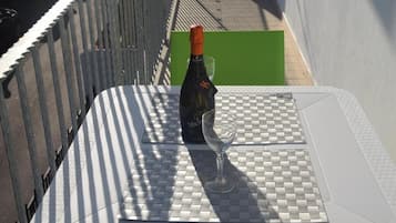 A bottle of wine and a glass on a checkered table mat.