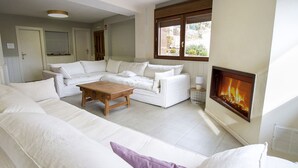 Un salon avec un canapé blanc, une table basse en bois et une cheminée.