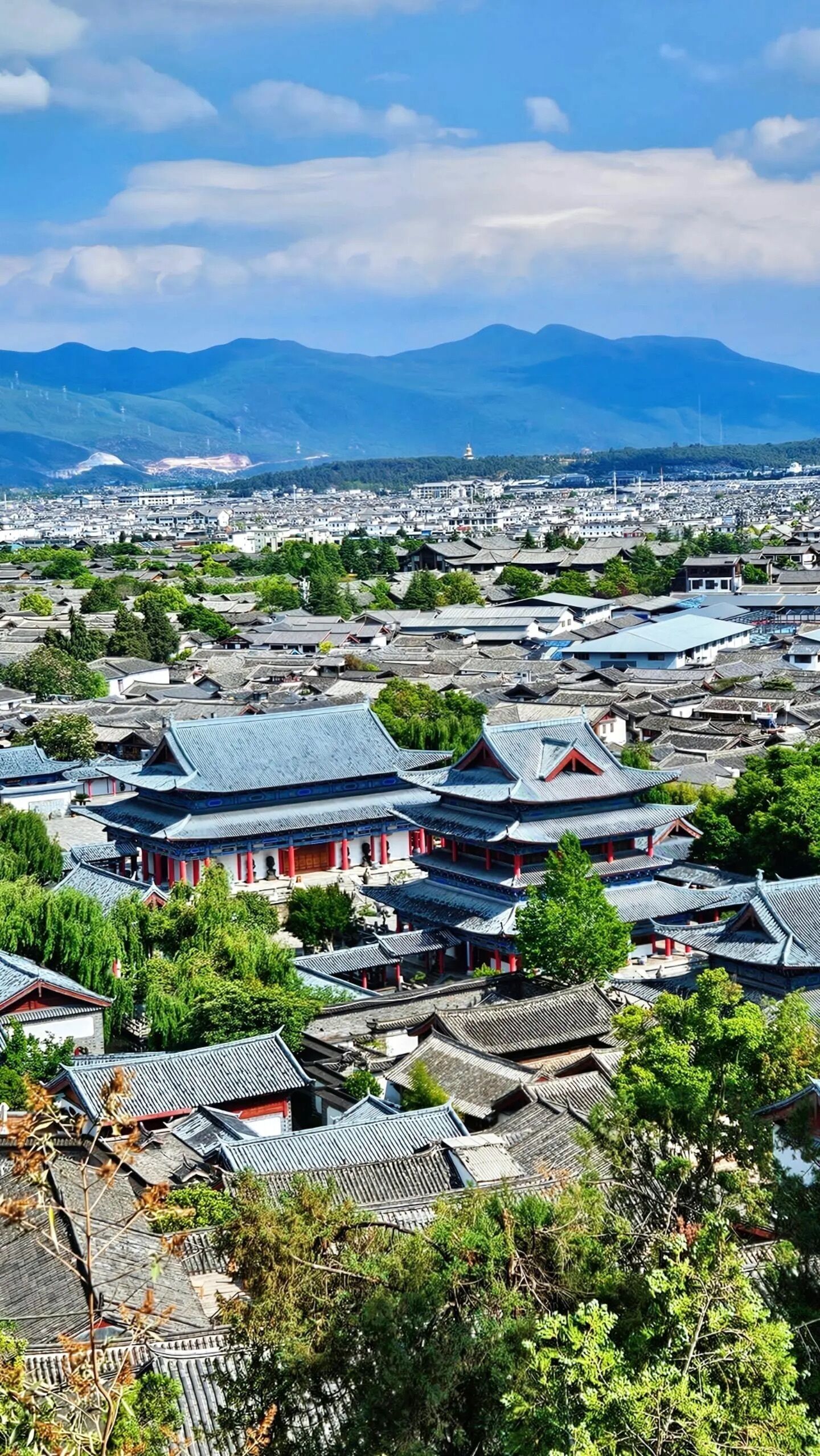 A traditional town with historical buildings, a prominent temple, and a mountainous backdrop.