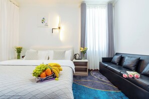 A hotel room with a bed, a black leather sofa, a bedside table with a vase of flowers, and a wall-mounted light fixture. - 166 Hotel-Ancient City Mufu Branch (Lijiang)