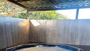 Un bain à remous doté d’une terrasse en bois et d’un escalier menant à celui-ci.