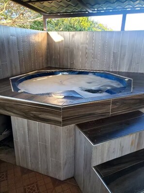A hot tub with a wooden deck and steps leading up to it. - Apartment away from the hustle and bustle of the city, with terrace and balcony. (San Francisco de Macorís)