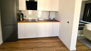 A compact kitchen with white cabinets, a stainless steel refrigerator, and a wooden countertop. - Casa Lara Hermigua - Superior Apartment with a large terrace (Hermigua)