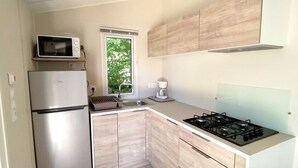 A modern kitchen with a stainless steel refrigerator, a microwave, a gas stove, and wooden cabinetry. - Mobile home, pets welcome - 4 guests (Chaillé-les-Marais)