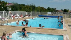 A swimming pool with multiple lanes, sun loungers, and a lifeguard stand. - Mobile home, pets welcome - 4 guests (Chaillé-les-Marais)