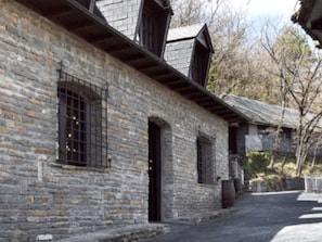 Ein Gebäude aus Stein mit Bogenfenstern und einem geneigten Dach.