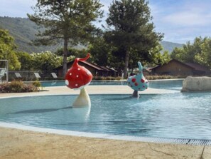 A swimming pool with two mushroom-shaped sculptures. - Cozy mobile home, pets welcome - 2 guests (Boltaña)
