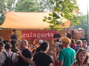 Ein belebtes Freiluft-Event mit Bühne und Banner.