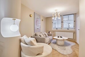Ein modernes Wohnzimmer mit einer Couch, einem runden Couchtisch und einer Pendelleuchte.
