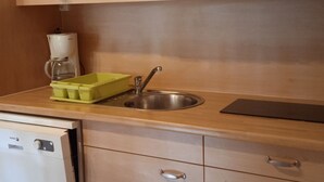 A kitchen with a microwave, coffee maker, sink, and a green dish rack. - Chalet pet-friendly - 5 guests (Pleaux)