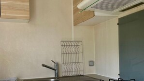 Eine moderne Küche mit Spüle aus Edelstahl, einem Gasherd und einem eingebauten Drahtgestell.