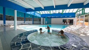 Ein Schwimmbereich mit Whirlpool, Liegestühlen und einer überdachten Dachkonstruktion.