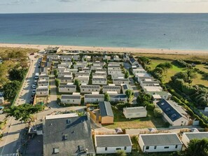 A caravan park with rows of caravans, a beach in the background, and a road leading to the beach. - Mobile home for 6 guests (Sarzeau)