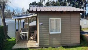 Une petite cabane dotée d’un porche abrité, d’une fenêtre et d’une porte.