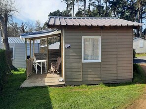 A small cabin with a covered porch, a window, and a door.