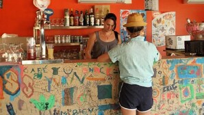 Eine Bar mit einer mit Graffiti beschrifteten Theke und einer roten Wand.