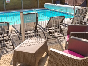 A poolside area with wicker lounge chairs and a pool. - Mobile home, pets welcome - 4 guests (Perros-Guirec)