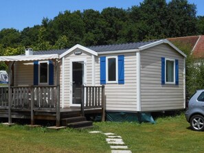 A mobile home with a porch, a door, and a window with shutters. - Cozy mobile home - 2 guests (Éguzon-Chantôme)
