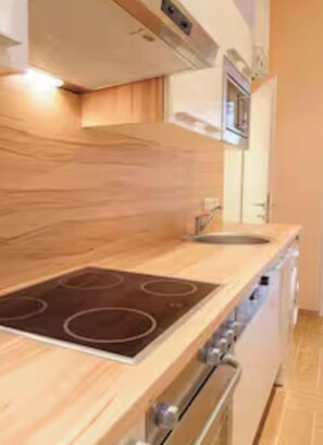 Eine moderne Küche mit Holzarbeitsplatte, eingebautem Backofen und Edelstahlgeräten.
