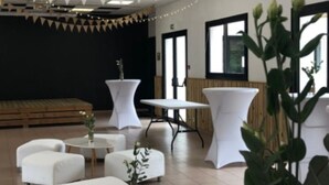 Un interior moderno con mesas redondas, sofás blancos y plantas en macetas.