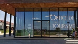 Un bâtiment moderne doté de grandes fenêtres en verre et d’un toit en bois.