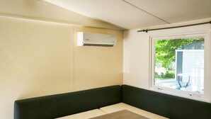 Une petite pièce fermée, avec un banc, une table et une fenêtre.