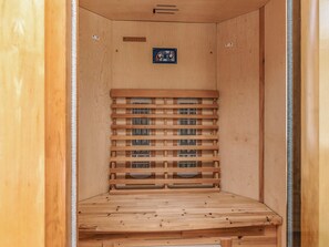 A sauna room with a wooden bench, ventilation system, and a control panel. - 10 Person Holiday Home in Spottrup (Spøttrup)