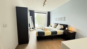 A bedroom with a bed, bedside table, lamp, and a view through a window. - Polished Antwerp Stay Steps to Hub (Antwerp)