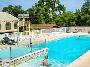 A swimming pool with a lifeguard tower, lounge chairs, and a fenced deck area. - Mobile home, pets allowed - 4 guests (Arrigny)
