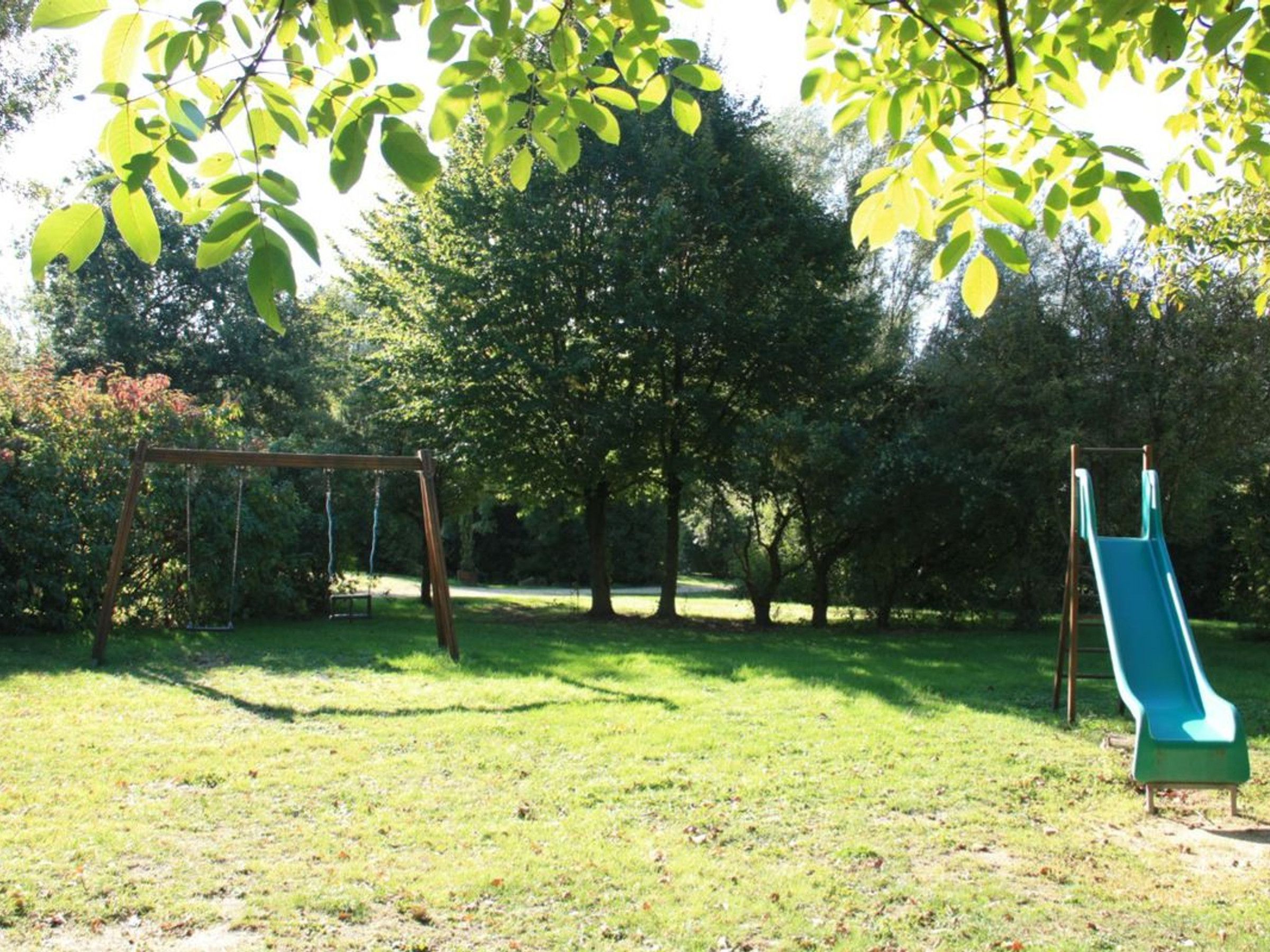 A park with a swing set and a slide.