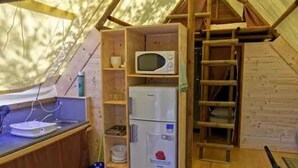 Une cuisine compacte équipée d’un four à micro-ondes, d’un réfrigérateur et d’un évier.
