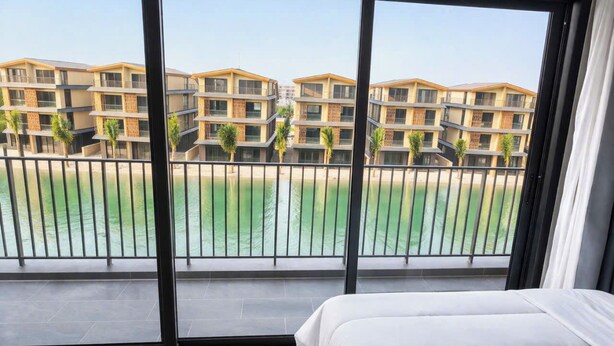 Une chambre d’hôtel avec une grande fenêtre, un lit et une vue sur une piscine et des immeubles.