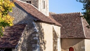 A historic building with a stone facade, a red door, and a bell tower. - Mobile home, pets welcome - 5 guests (La Châtre)
