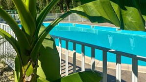 A swimming pool with a white fence, surrounded by greenery. - Mobile home with air conditioning - 4 guests (Monplaisant)