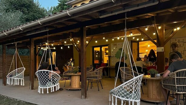 An outdoor seating area with wicker chairs and hanging lights. - Mobile home with air conditioning - 4 guests (Monplaisant)