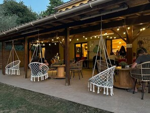 An outdoor seating area with wicker chairs and hanging lights. - Mobile home with air conditioning - 4 guests (Monplaisant)