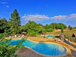 Ein Schwimmbecken mit Liegestühlen und einem Holzzaun.
